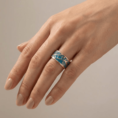 Anel de ouro rosé com pedra turquoise e design místico, da marca Rose & Oliver, exibido em close na imagem.