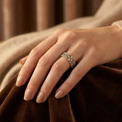 Anel de anel de prata e ouro com design ornamentado, da marca Rose & Oliver, exibido em close na imagem.