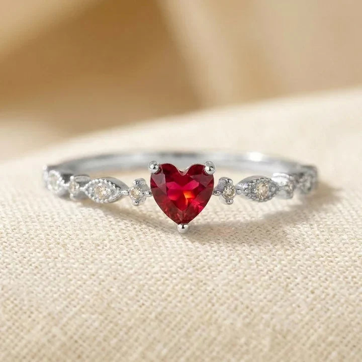 Anillo de oro con corazón de rubí de Rose & Oliver, destacando su diseño delicado y la piedra roja central.