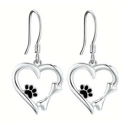 Brincos Yaritza™ de plata con colgantes de pata y corazón, elegantes brincos de Rose & Oliver con detalles delicados.