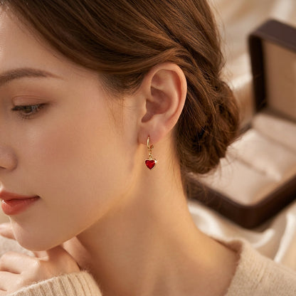 Brincos de ouro com gotas de rubi em formato de coração, da marca Rose & Oliver, com detalhes elegantes e acabamento refinado