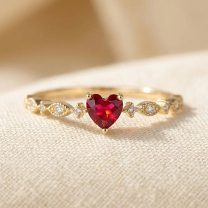 Anillo de oro con corazón de rubí de la marca Rose & Oliver, mostrando el diseño delicado y los detalles brillantes de la joya.