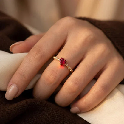 Anillo de oro con corazón de rubí de Rose & Oliver, detalles delicados y brillo del rubí central en un marco de oro.