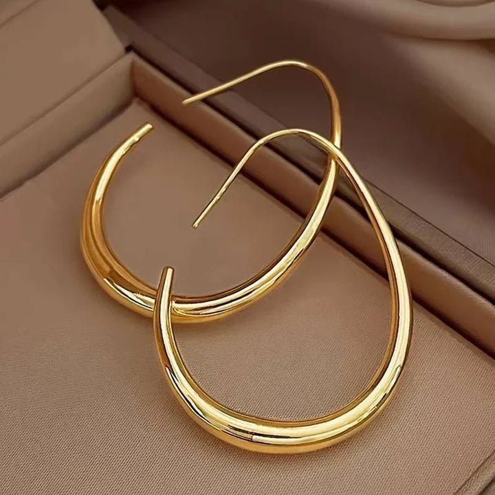 Aretes de argolla dorados con acabado antiguo de la marca Rose & Oliver, hechos de oro, detalles elegantes y clásicos.