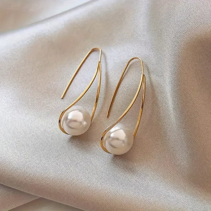 Aretes de oro con perlas colgantes, elegantes y sofisticados, de la marca Rose & Oliver.